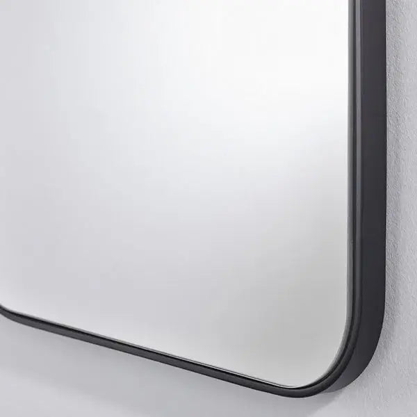 Détail du cadre métal noir mat aux coins arrondis du miroir pour entrée