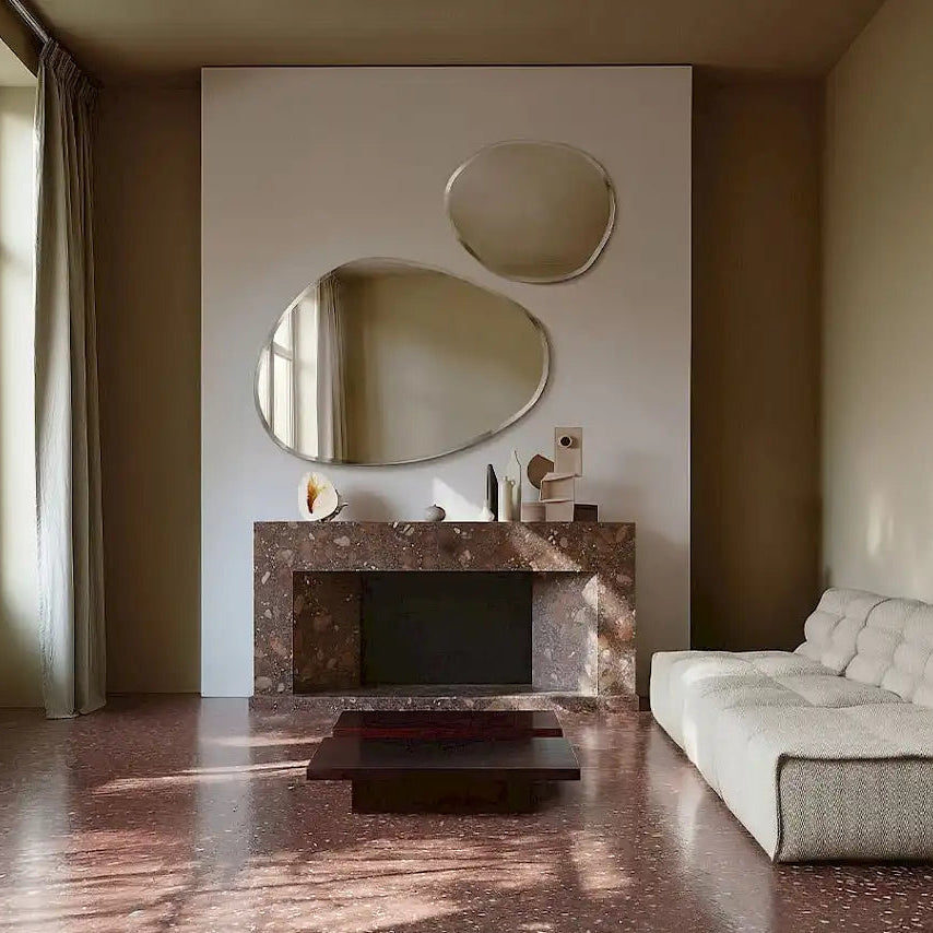 Grand miroir asymétrique apportant profondeur et lumière dans une pièce