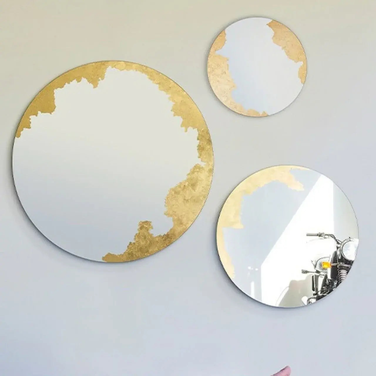 Contraste saisissant entre les feuilles d'or et la surface réfléchissante du miroir
