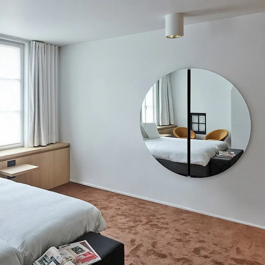 Grand miroir rond noir 150 cm accroché dans une chambre design